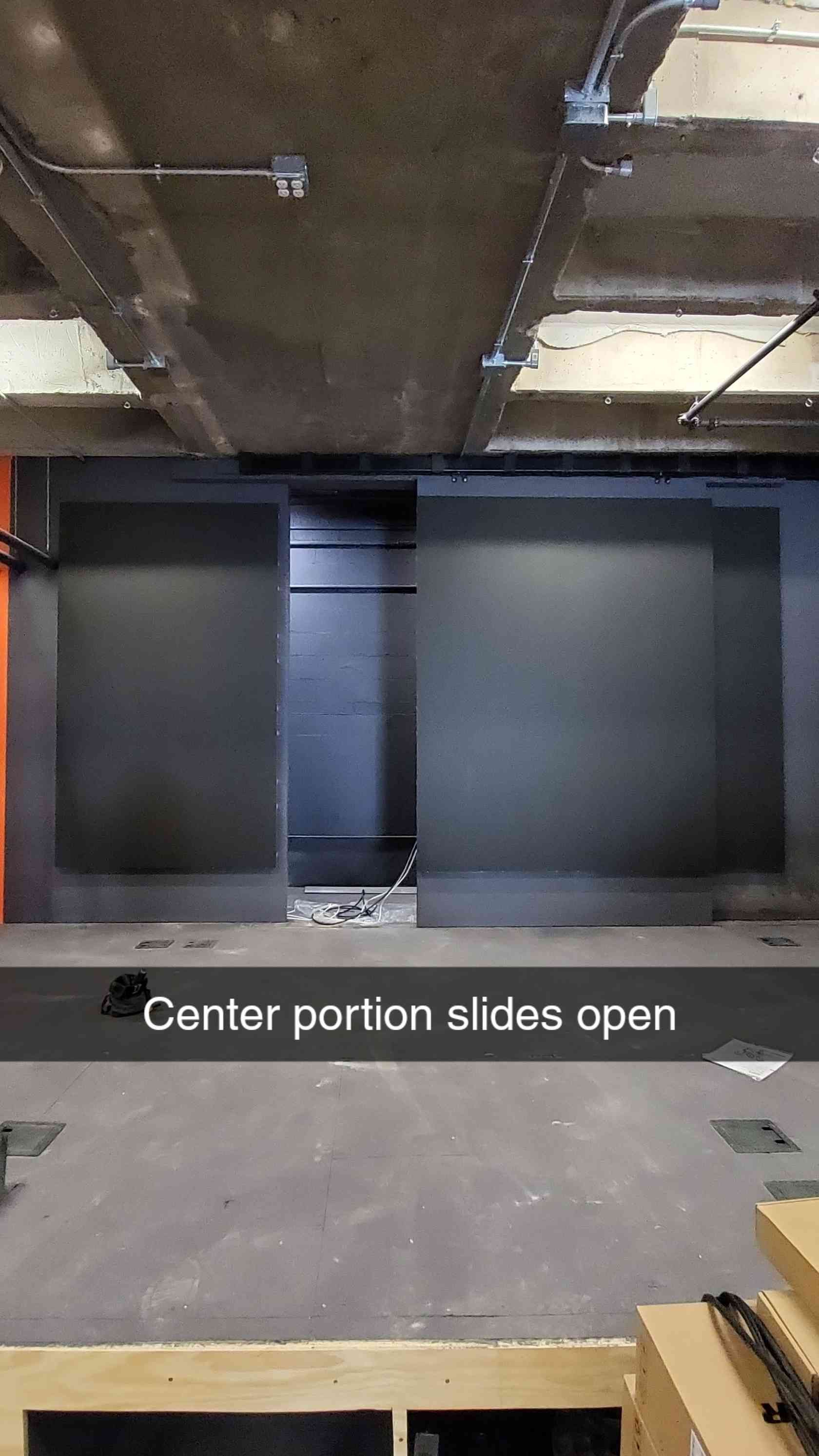 Overhead shot of a room with a large, dark panel that slides open in the center.