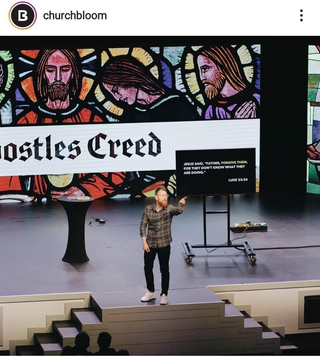 Man in church pointing at screen with 