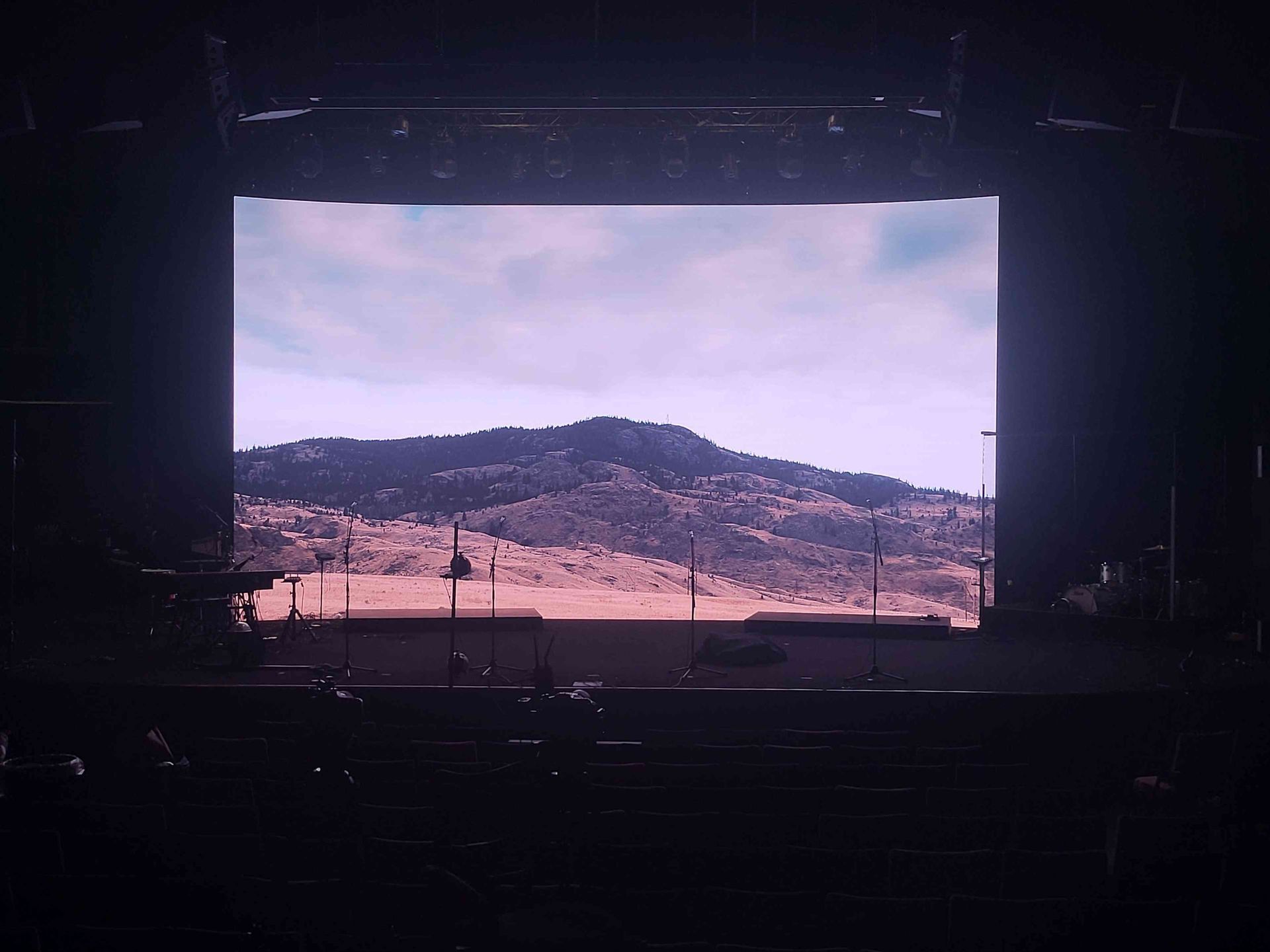 Stage screen displays a mountain landscape with a pale sky. The stage is dark.