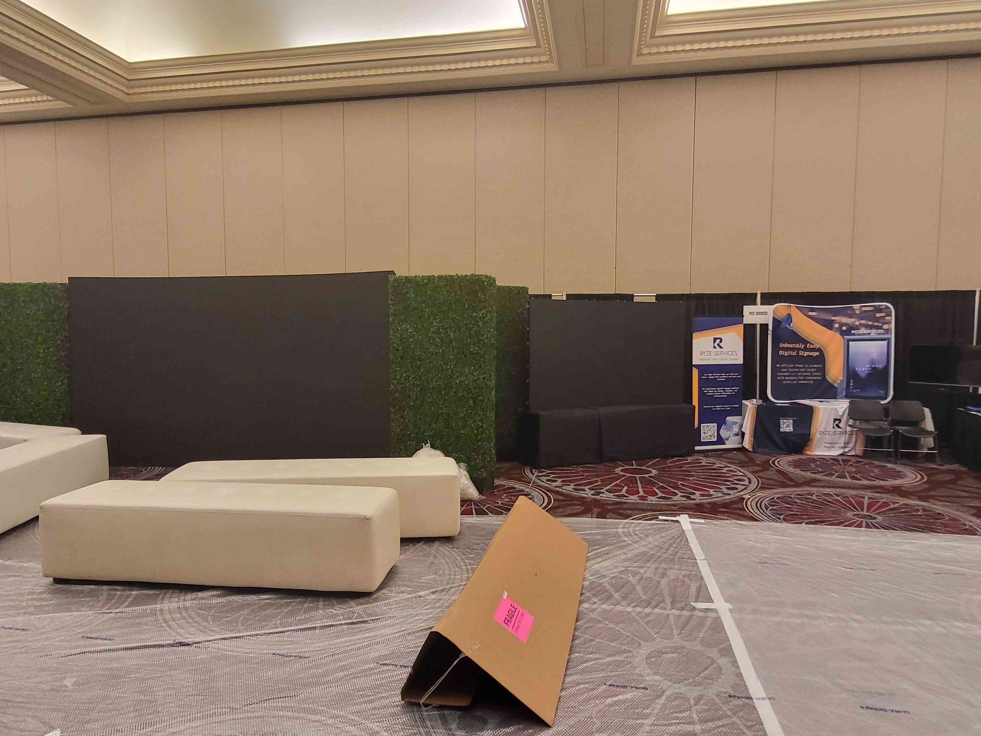 Empty conference room with stage and seating. Cardboard prop in foreground.