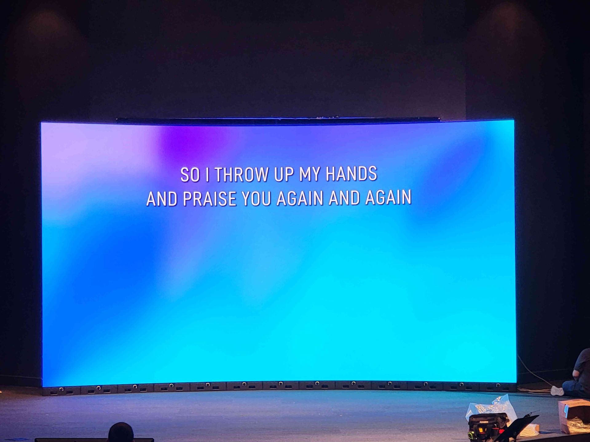 Large screen displaying lyrics: 