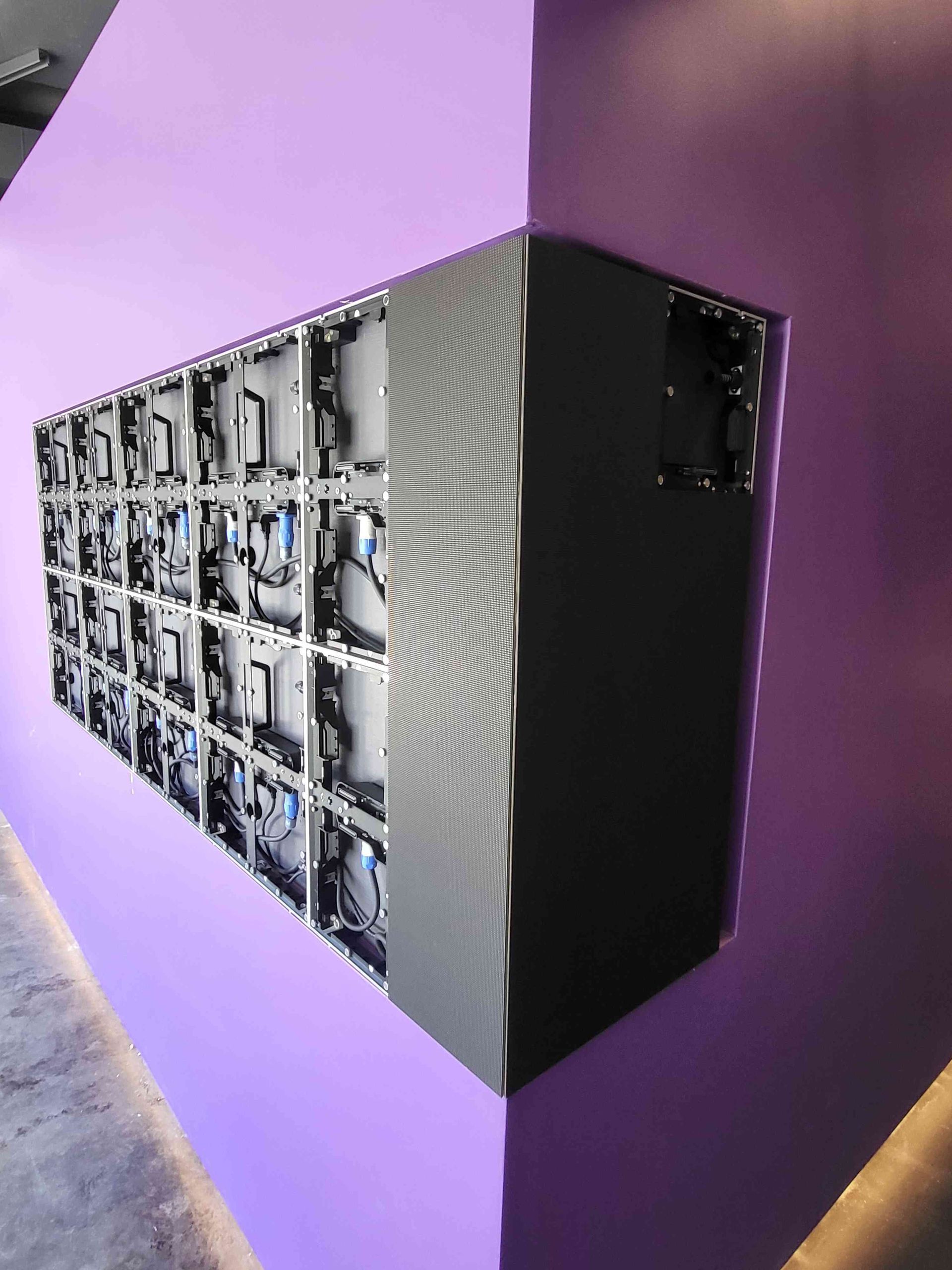 LED display screen on purple wall, angled view showing both front and internal components.