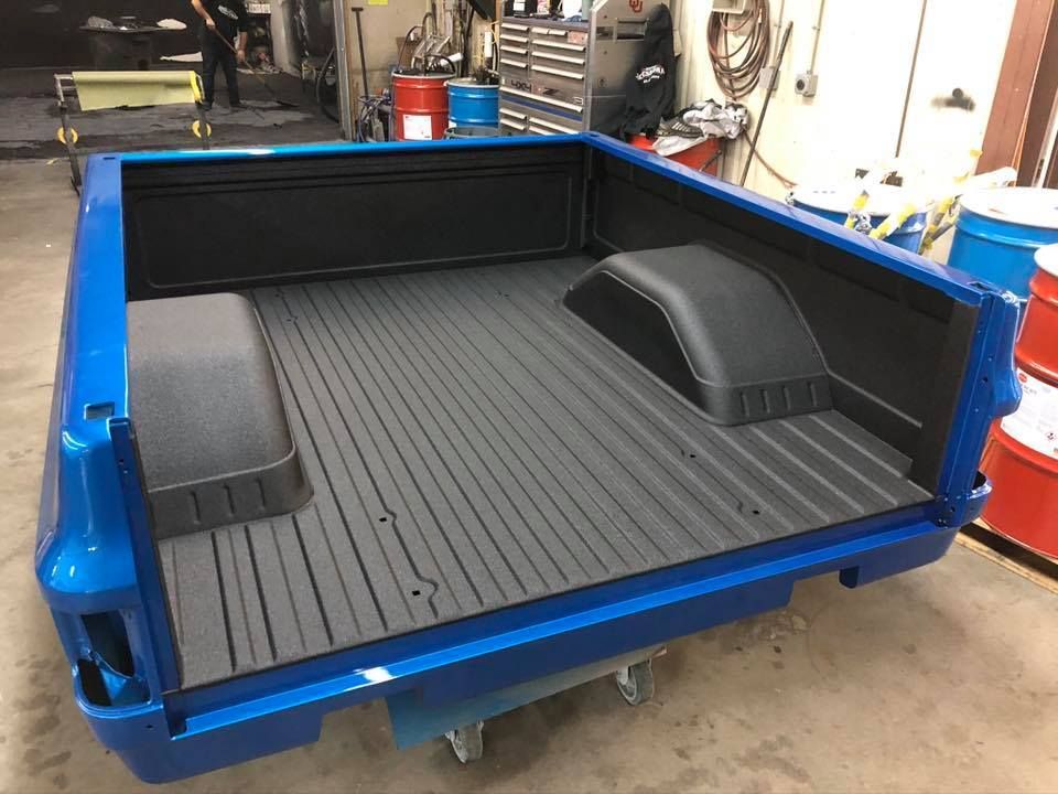 Blue truck bed with black bedliner.