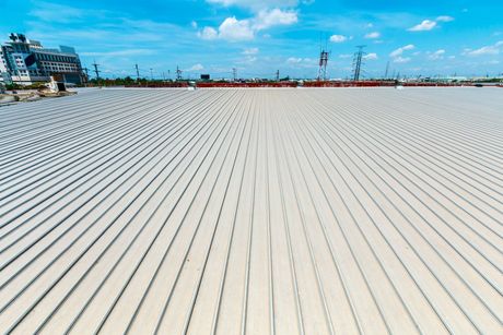 A large white roof with a blue sky in the background.