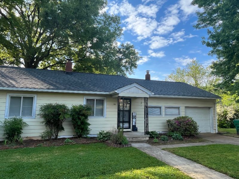 A white house with a gray roof and a white garage door