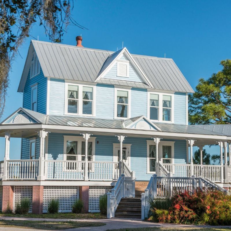 A large blue house with a porch and stairs