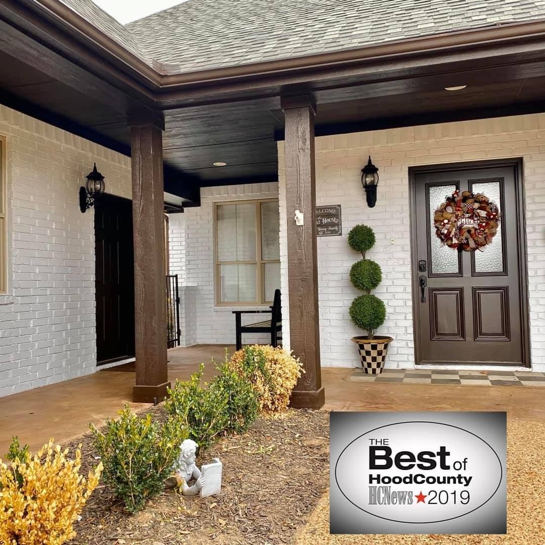 A house with a porch and a sign that says best of hood county
