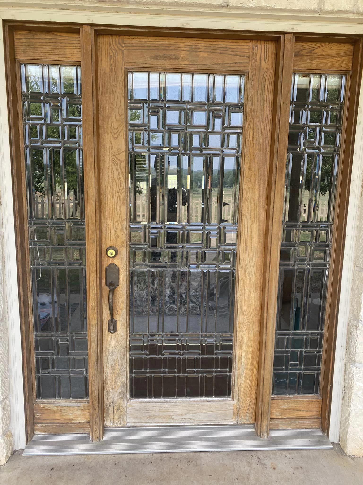 A wooden door with stained glass windows and a metal frame.
