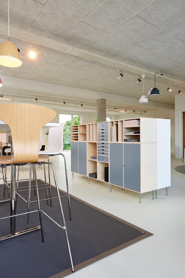 Modern office space with modular storage cabinets, wooden accents, and a bar area.
