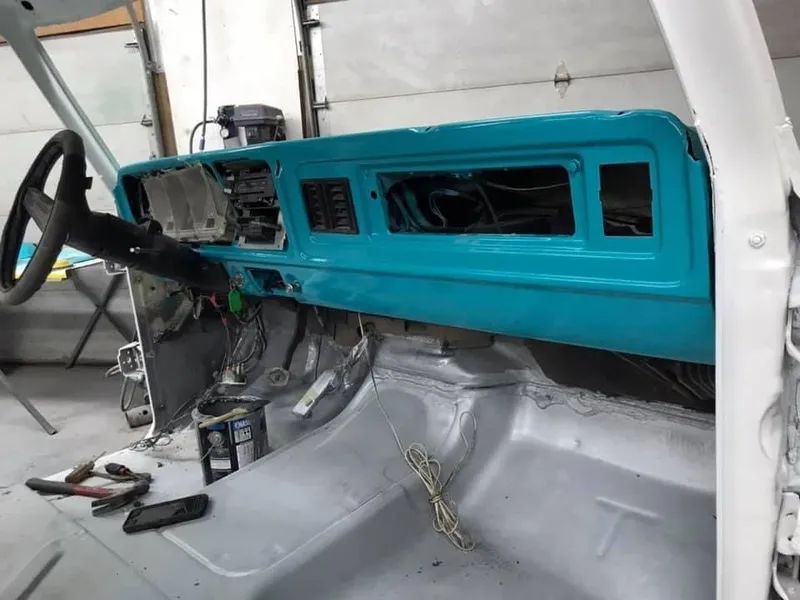 Light blue dashboard in a white vehicle interior; wiring exposed.