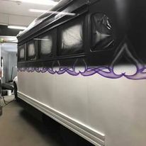Black and white vehicle with purple heart-shaped flames painted on its side in a workshop.