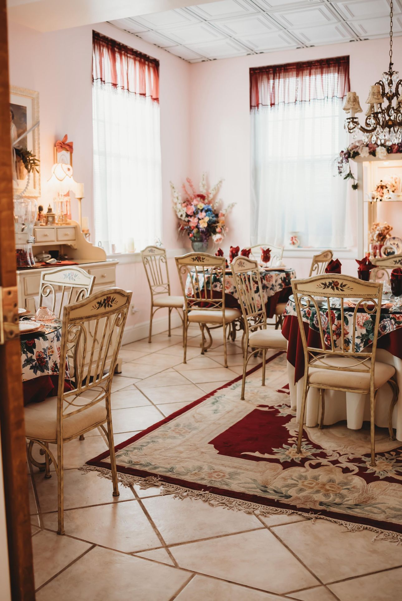 there are many tea tables and chairs in an elegant room