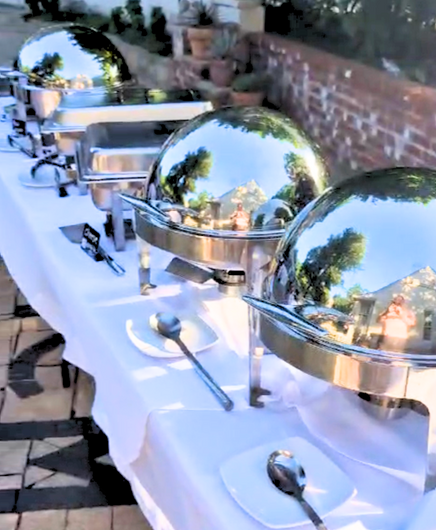 A long table with a bunch of buffet dishes on it.