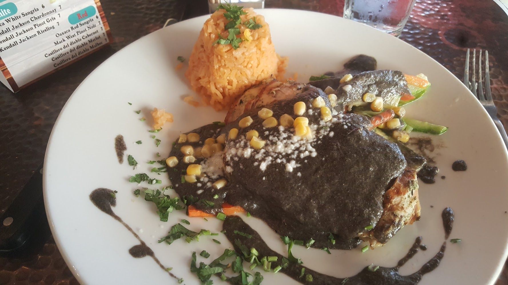 a white plate topped with meat and vegetables on a table
