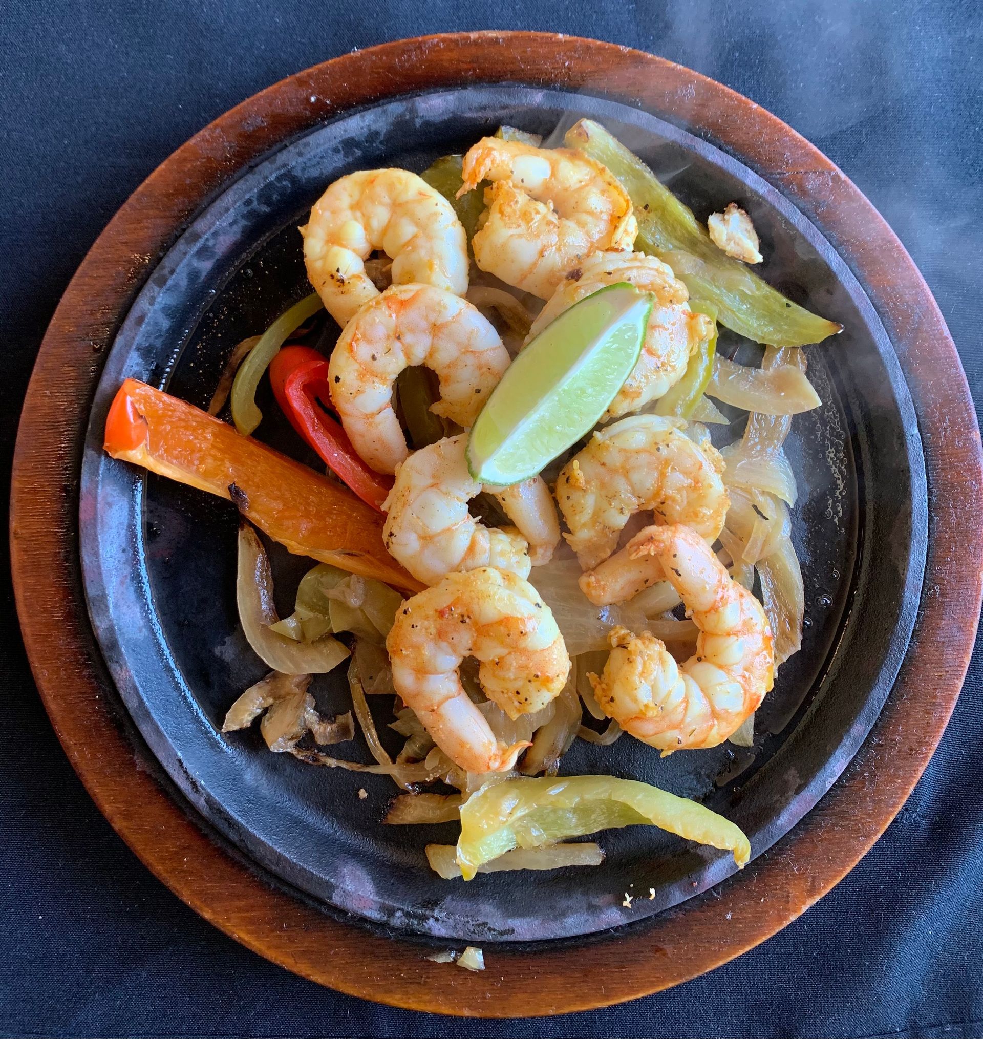a plate of shrimp and vegetables on a wooden plate
