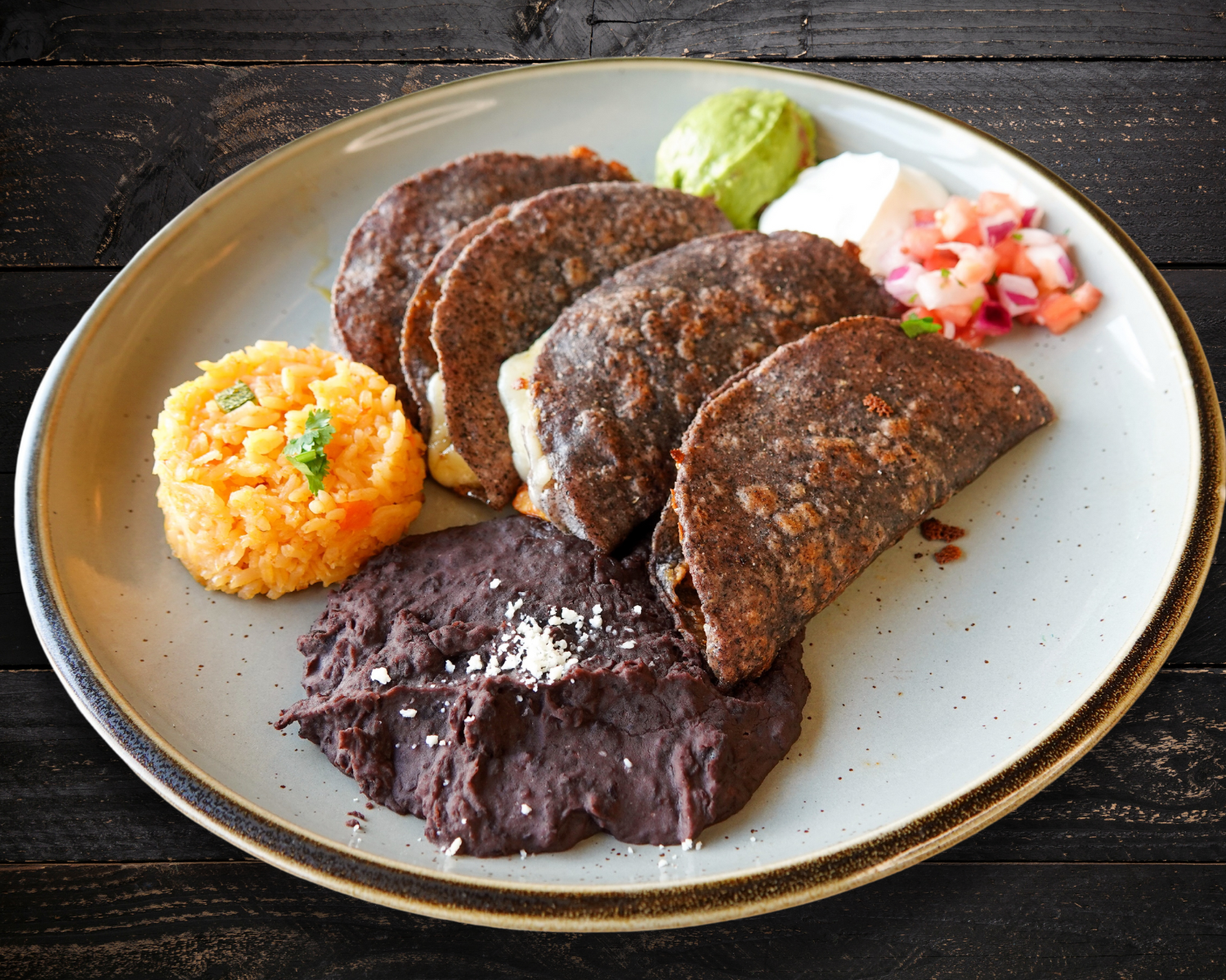a plate of food with beans and rice on a table