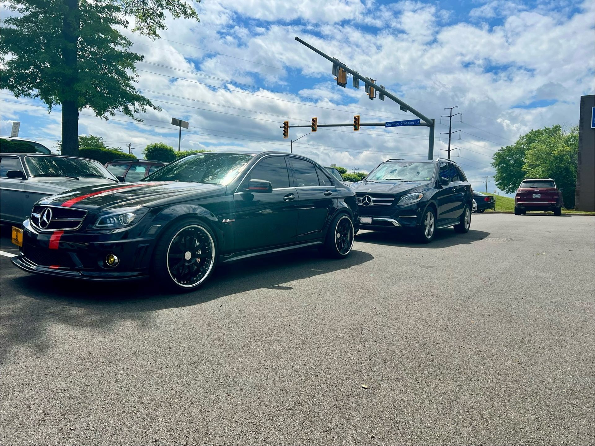 Two black cars are parked next to each other in a parking lot