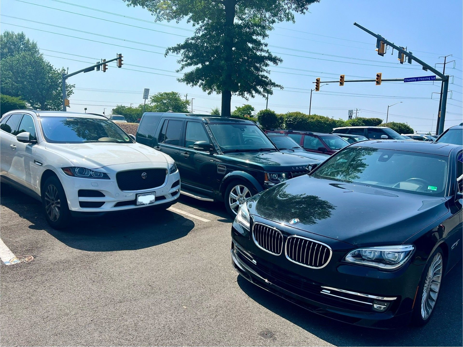 A white car and a black car are parked next to each other in a parking lot