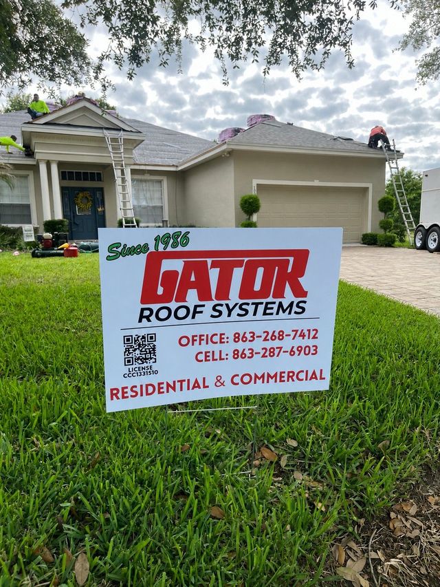 Lawn sign for Hator Roof Systems in front of a suburban house.