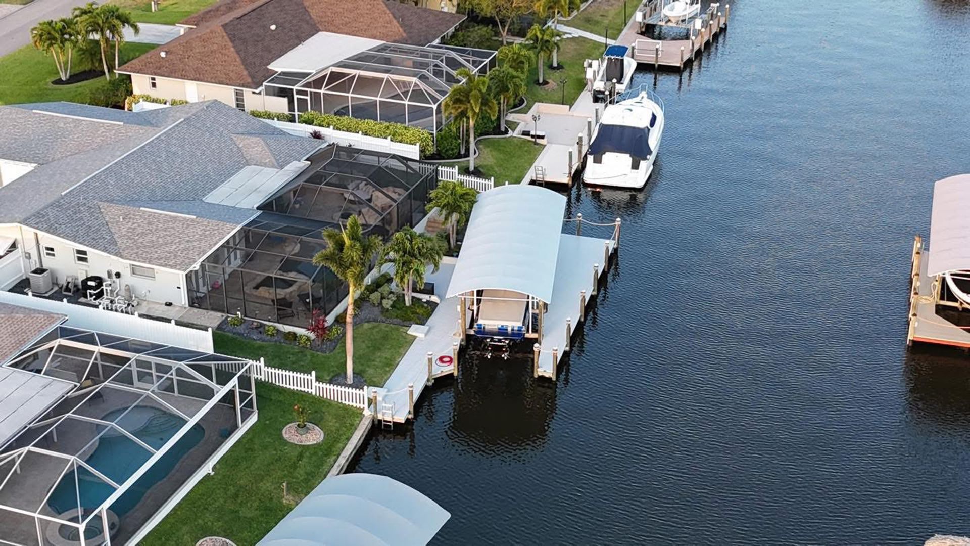 Aerial view of waterfront homes with docks, boats, and calm canal water