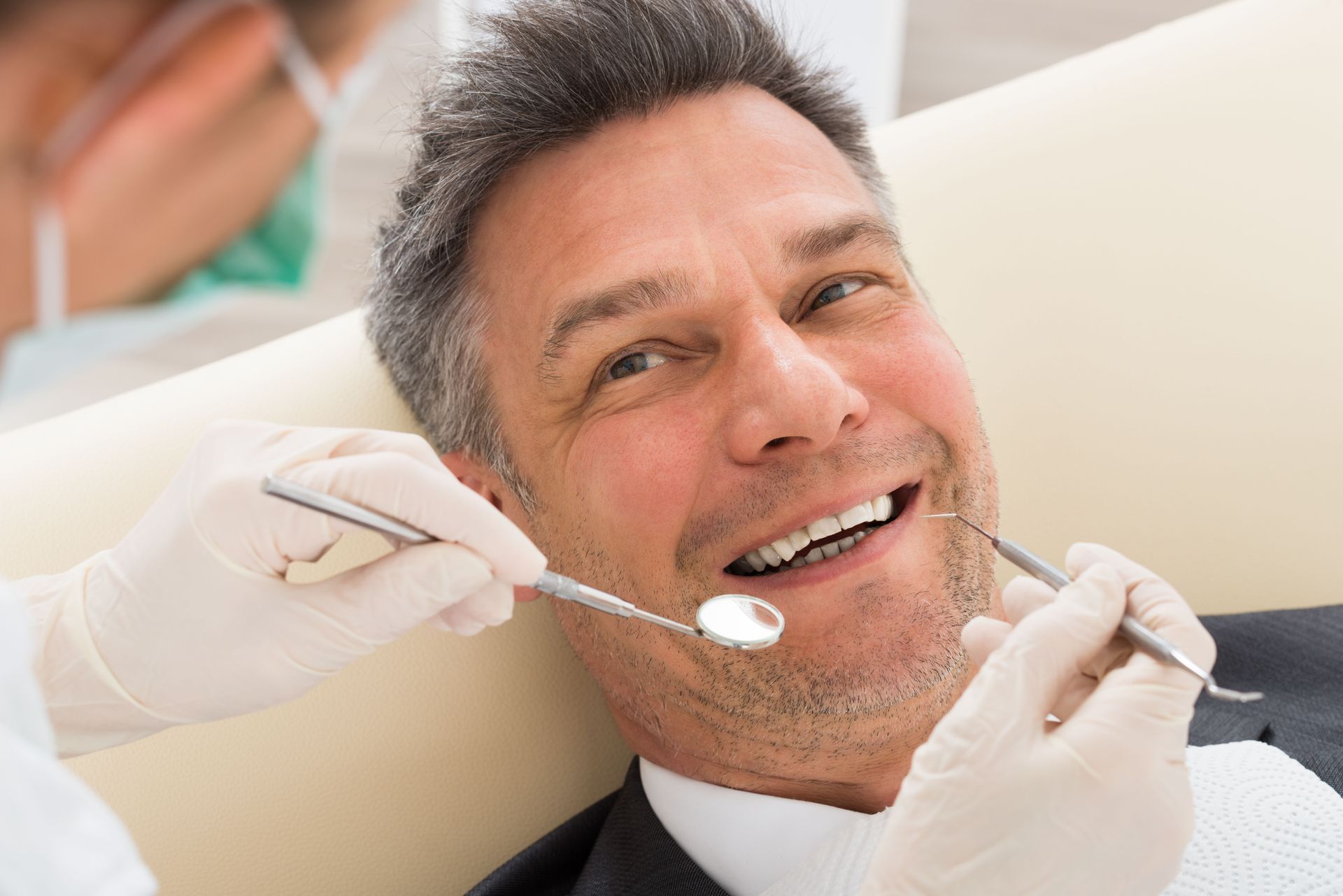 A dentist performing a checkup on a patient sitting in a dental chair.