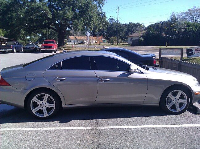 a silver car is parked on the side of the road