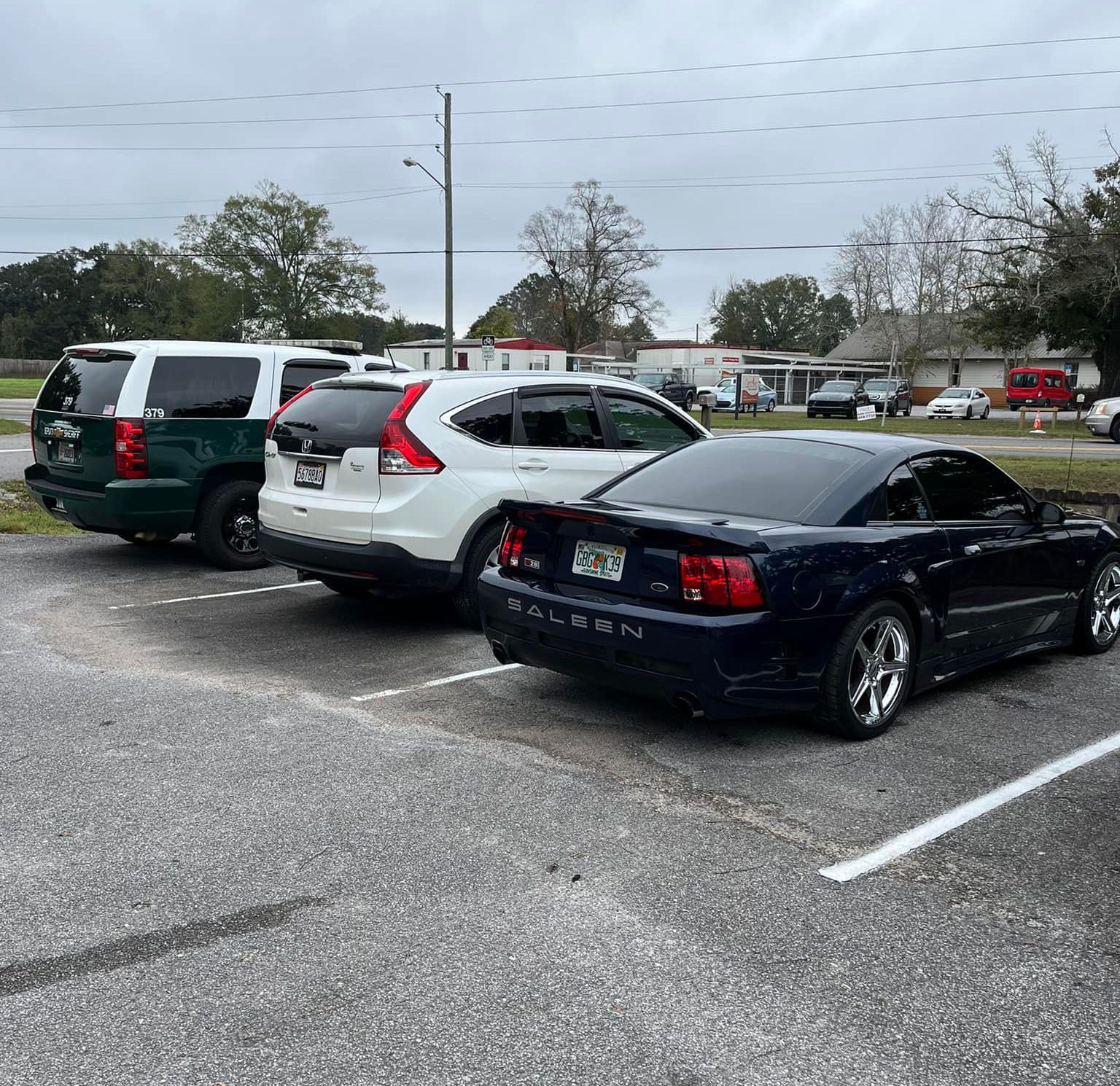 a row of cars are parked in a parking lot .