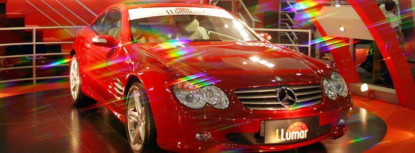 a red mercedes is on display at a car show
