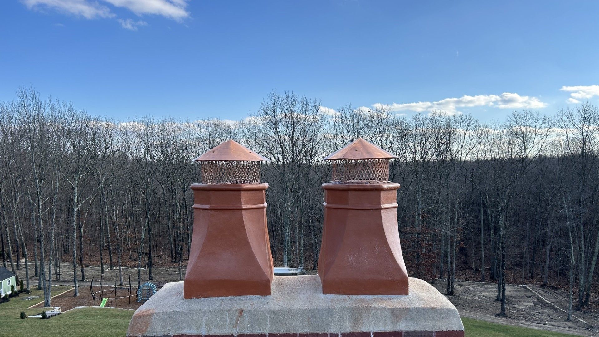 Two chimneys are sitting on top of a brick chimney.