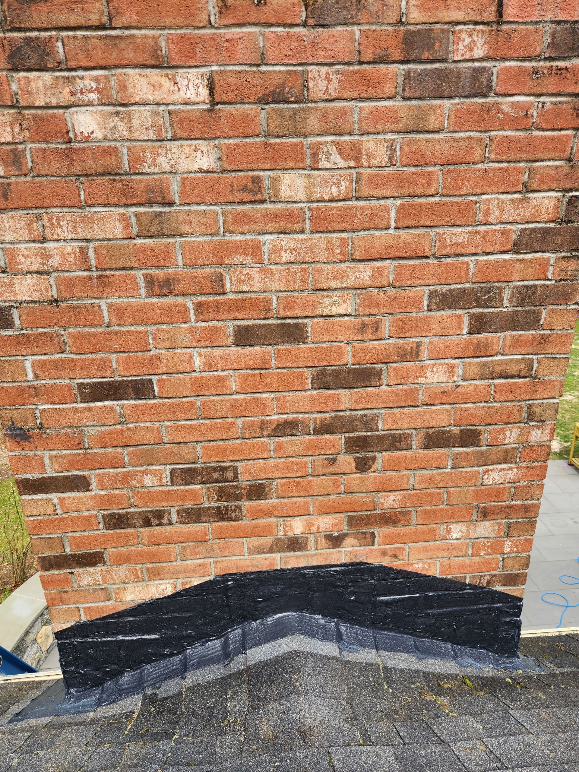 A brick wall with a black corner on it