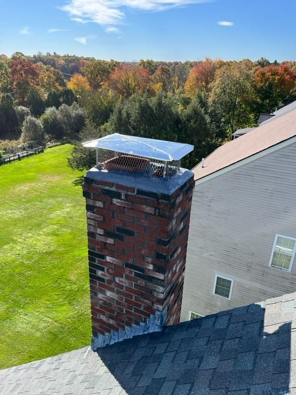 An aerial view of a brick chimney on the roof of a house.