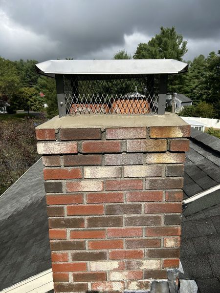A brick chimney is sitting on top of a roof.
