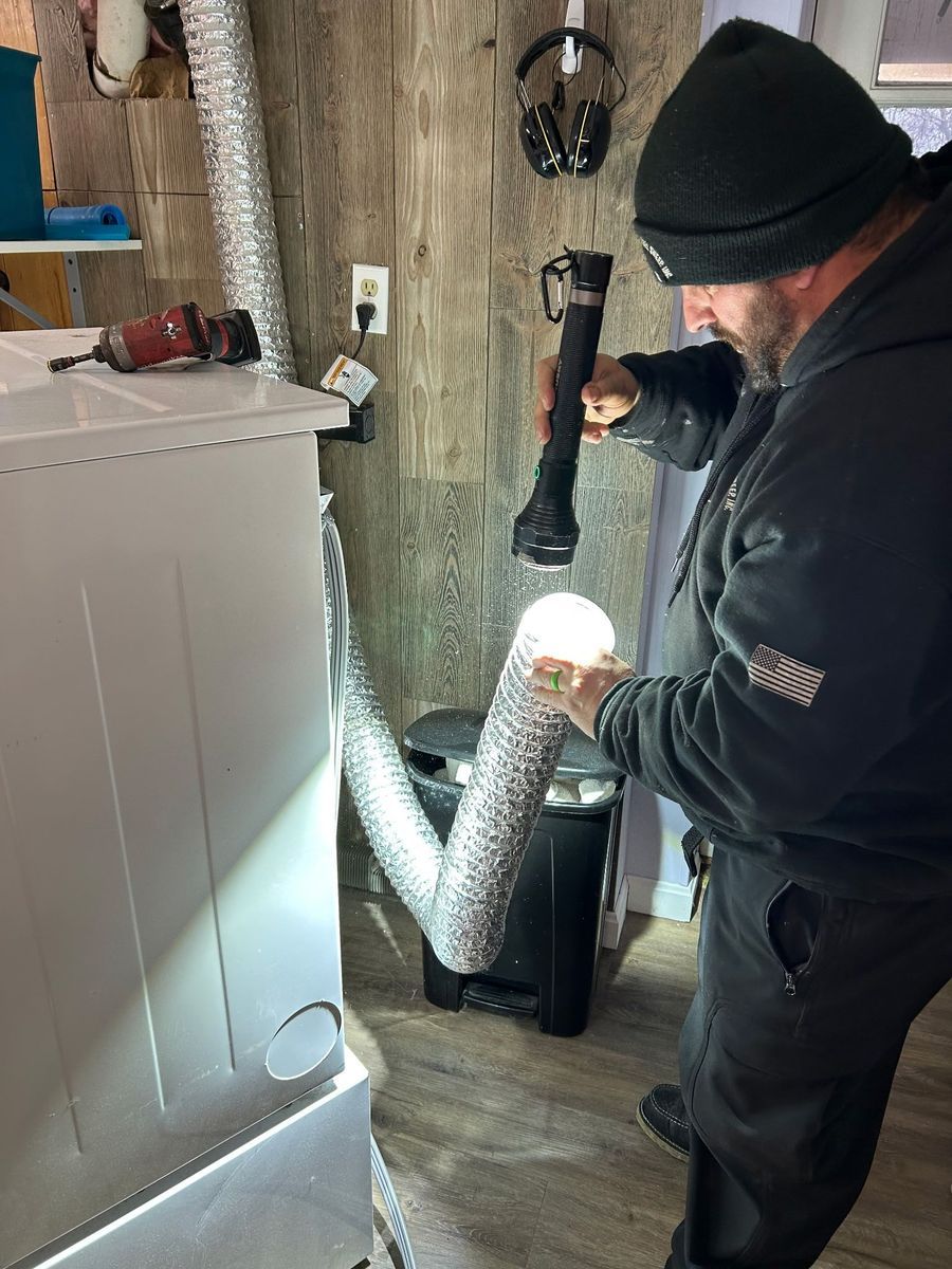 A man is holding a flashlight in a laundry room.