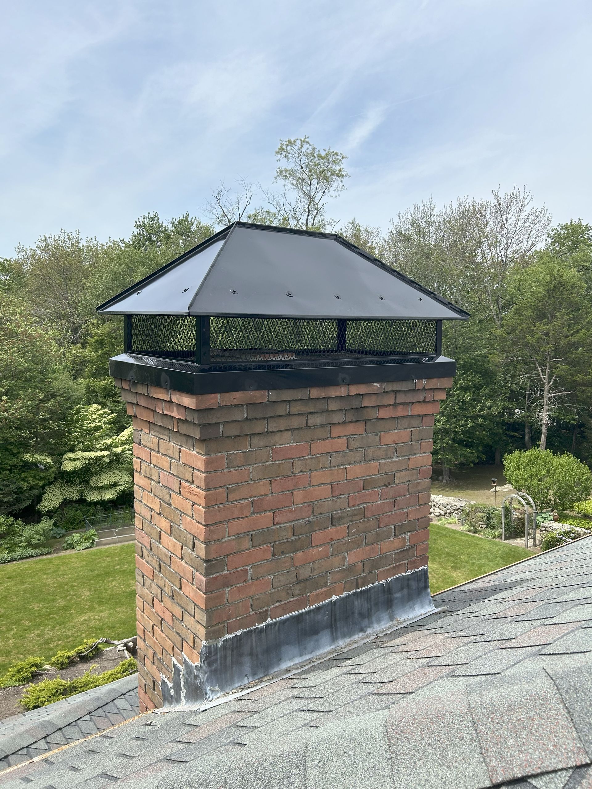A brick chimney is sitting on top of a roof.