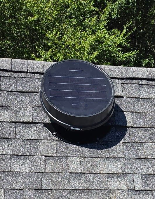 A black circular object is sitting on top of a roof.