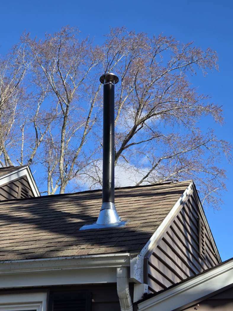 A chimney is sitting on top of a roof of a house.