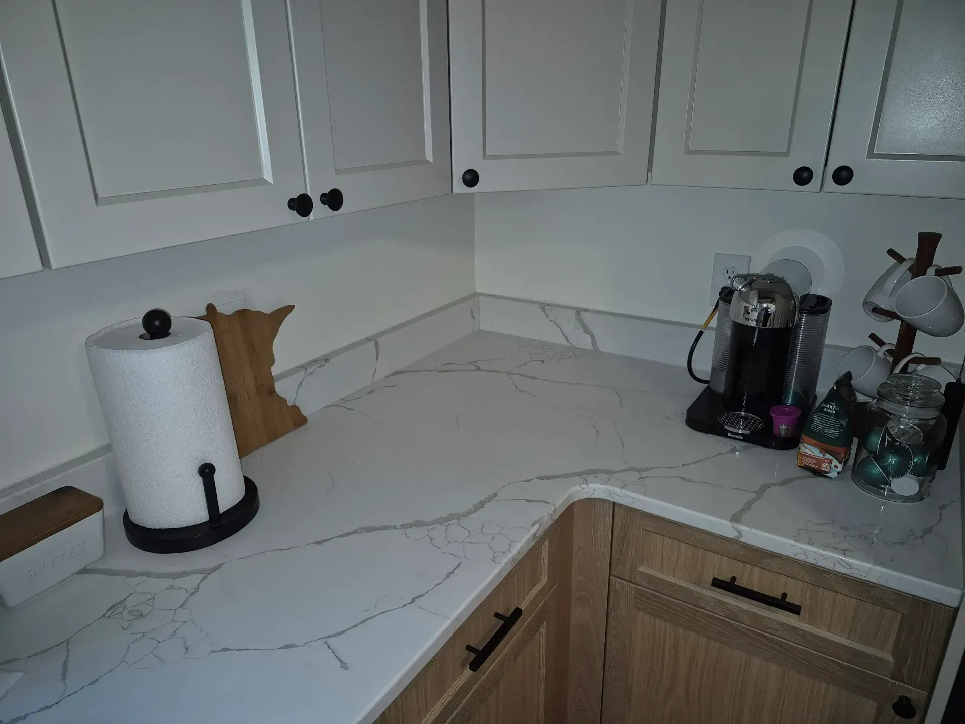 Kitchen corner with white cabinets, countertop, and appliances like a coffee maker.