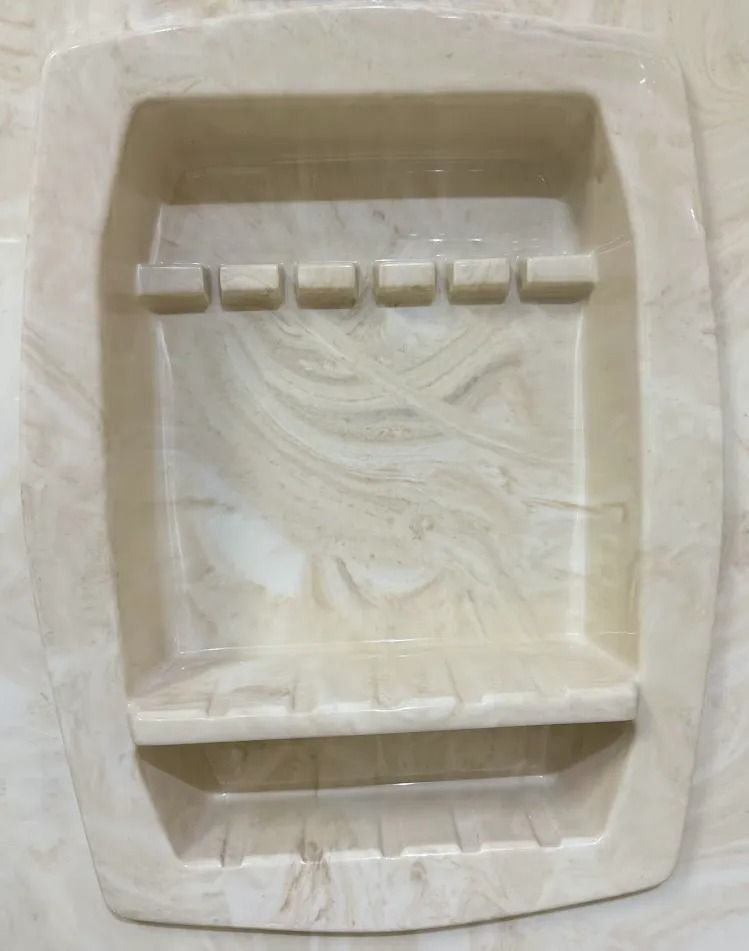 White ceramic soap dish with drainage grooves and a raised center on a beige surface