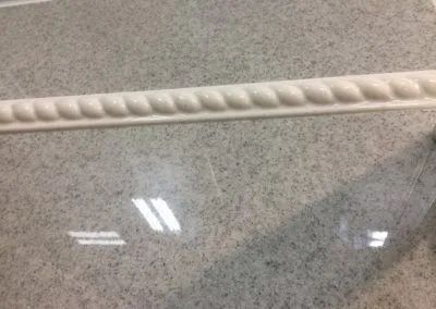 Polished gray countertop with a decorative white rope-like trim along the edge