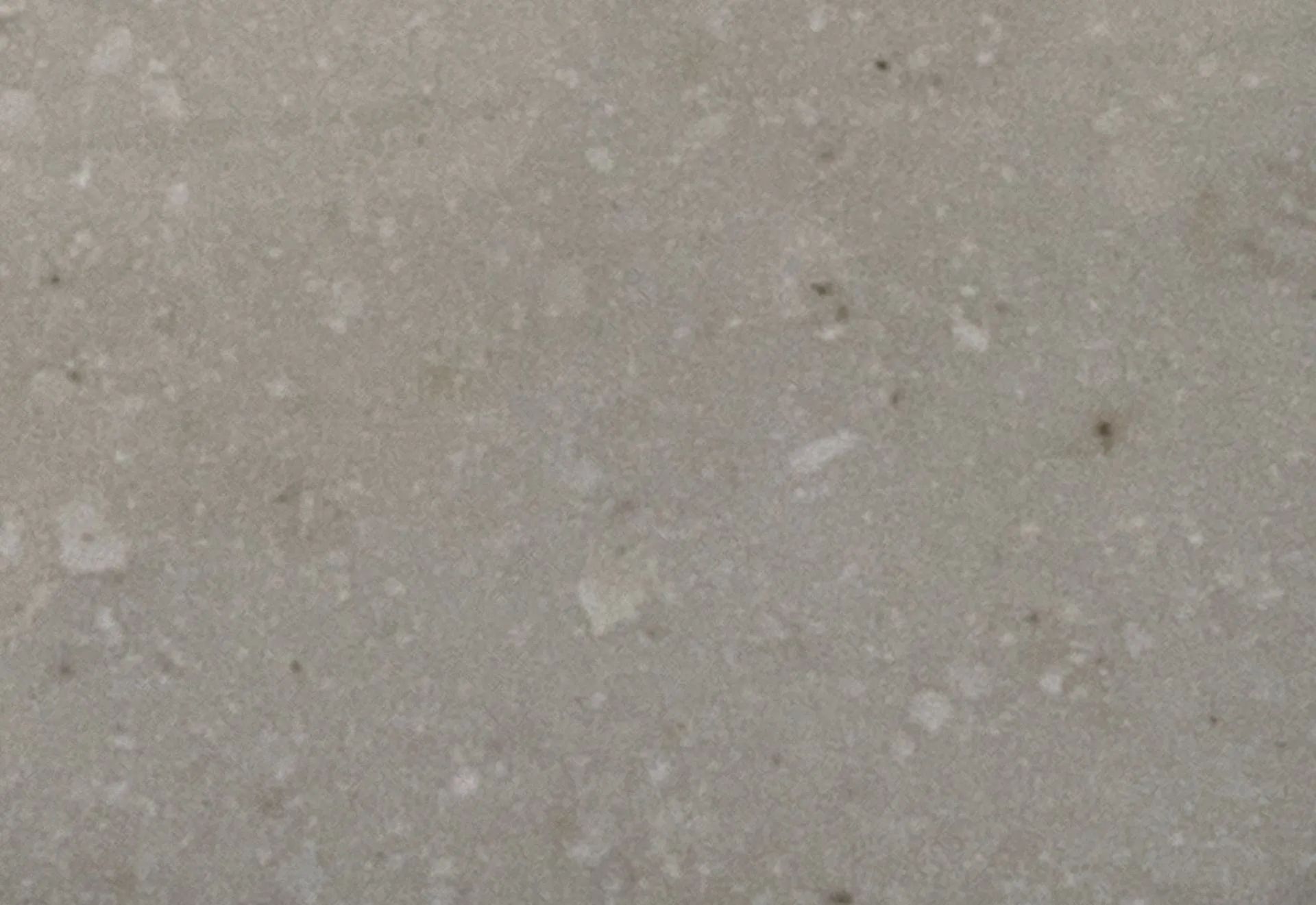 Close-up of a light beige speckled stone or concrete surface