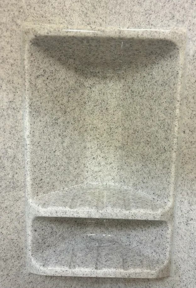 Empty speckled stone tray with a small divided compartment at the bottom