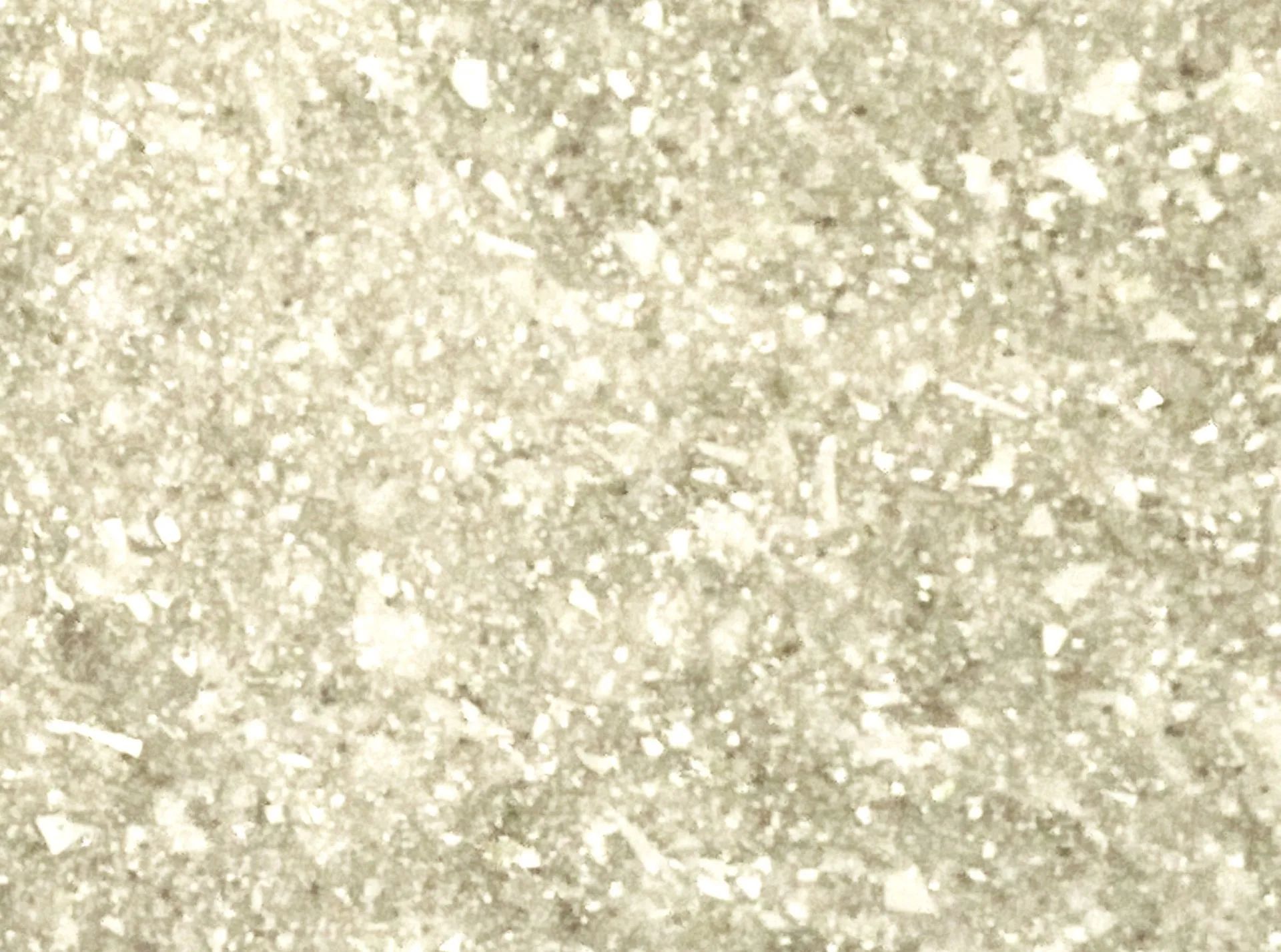 Close-up of a pale beige, speckled textured surface with a glittery, grainy appearance