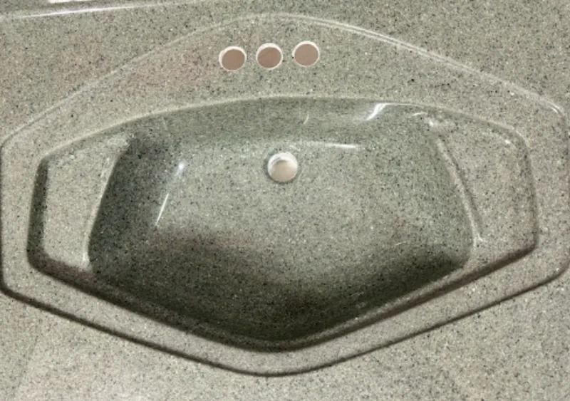 Gray speckled bathroom sink with an oval basin and chrome drain plug