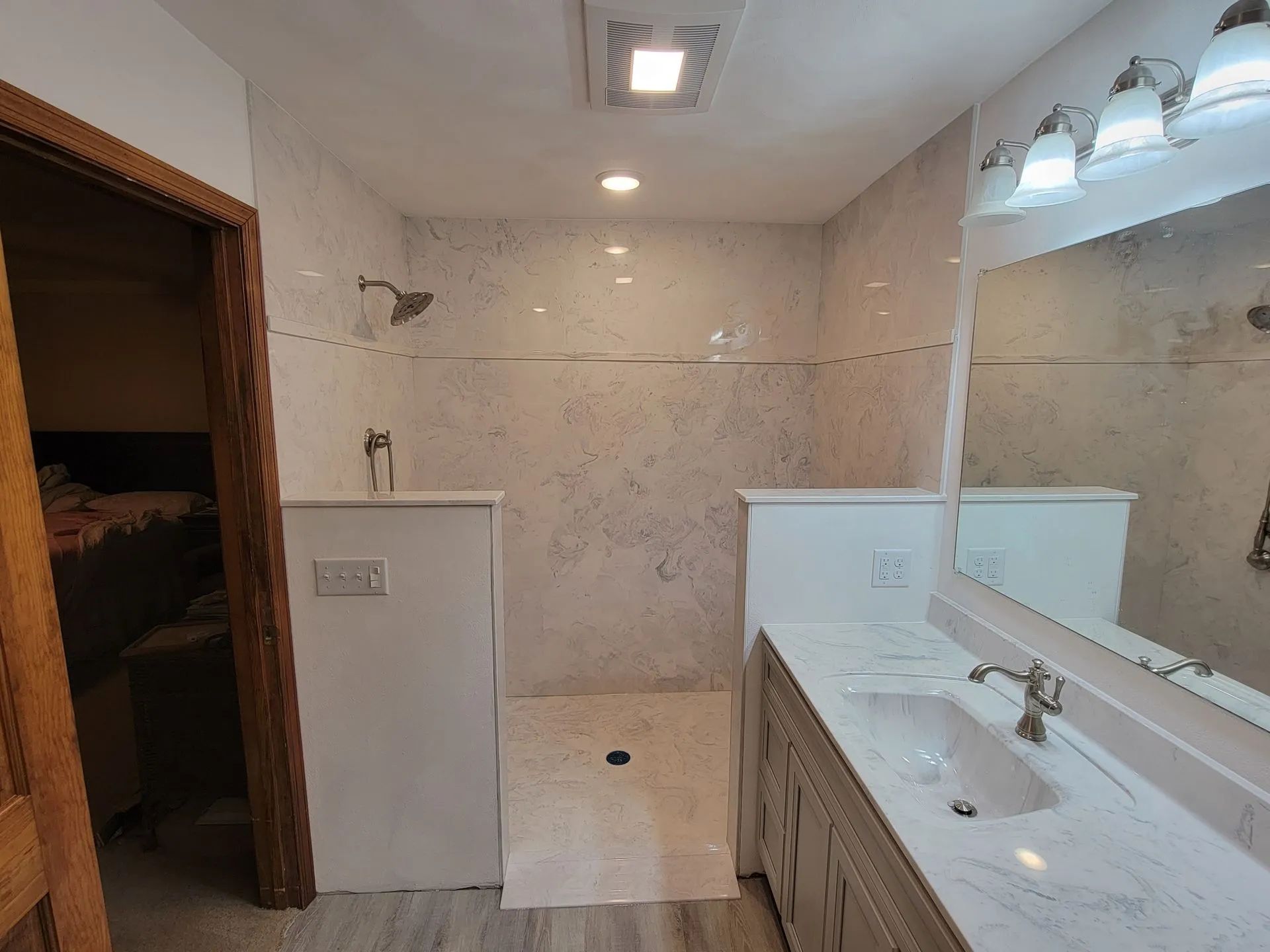 Bathroom with white tile, shower area, and double sink vanity with large mirror