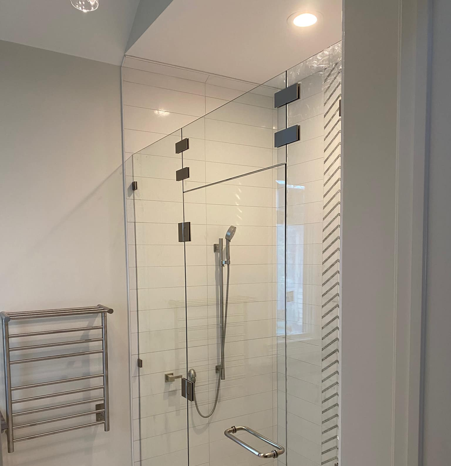 A bathroom with a shower and a towel rack