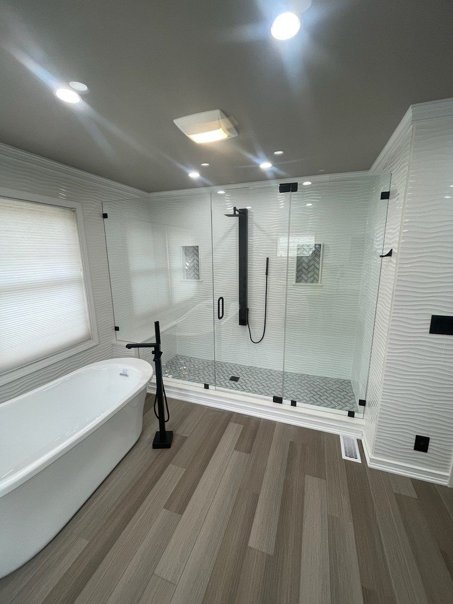 A bathroom with a bathtub and a walk in shower.