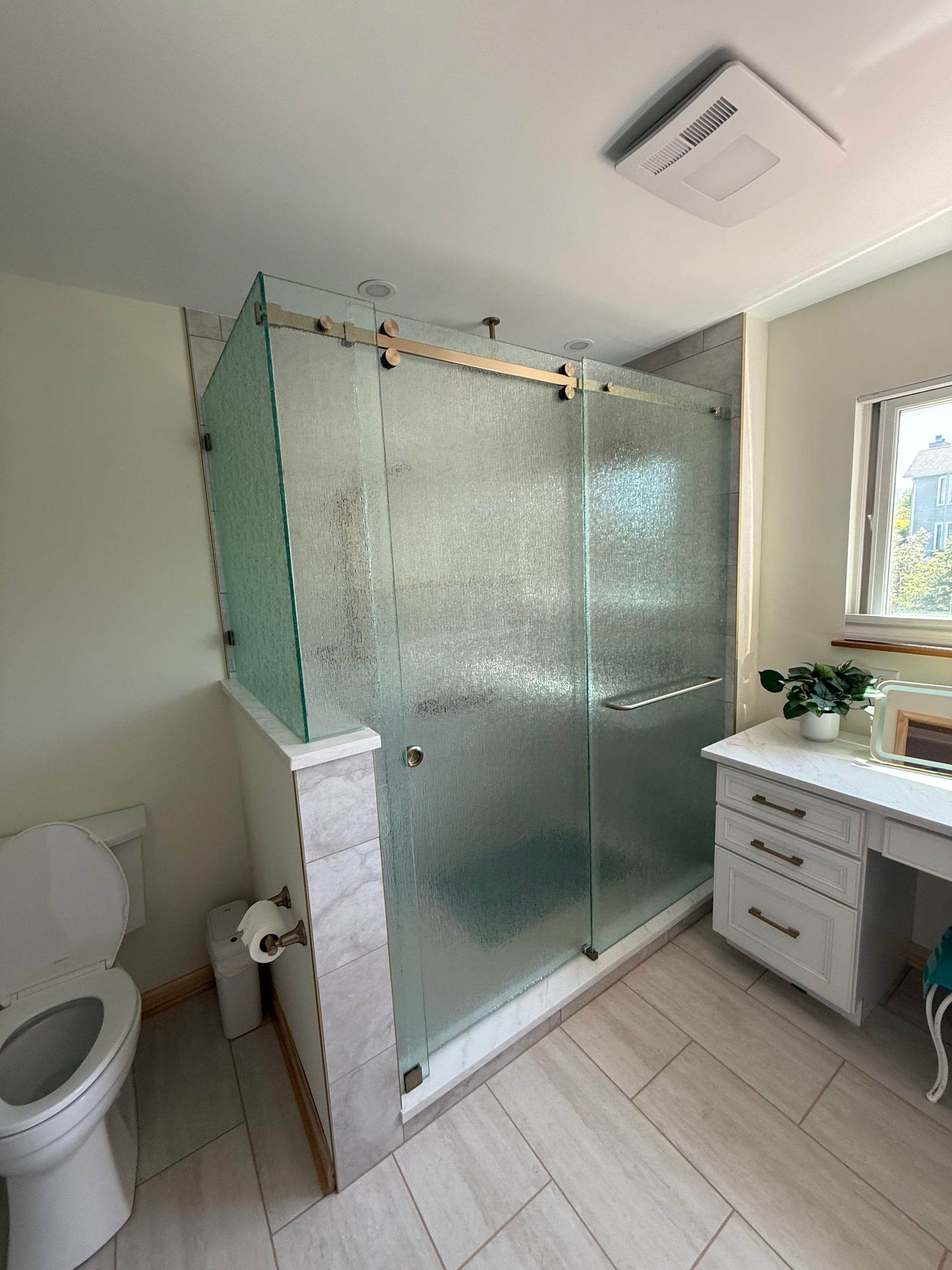 A bathroom with a toilet, sink, and shower stall.
