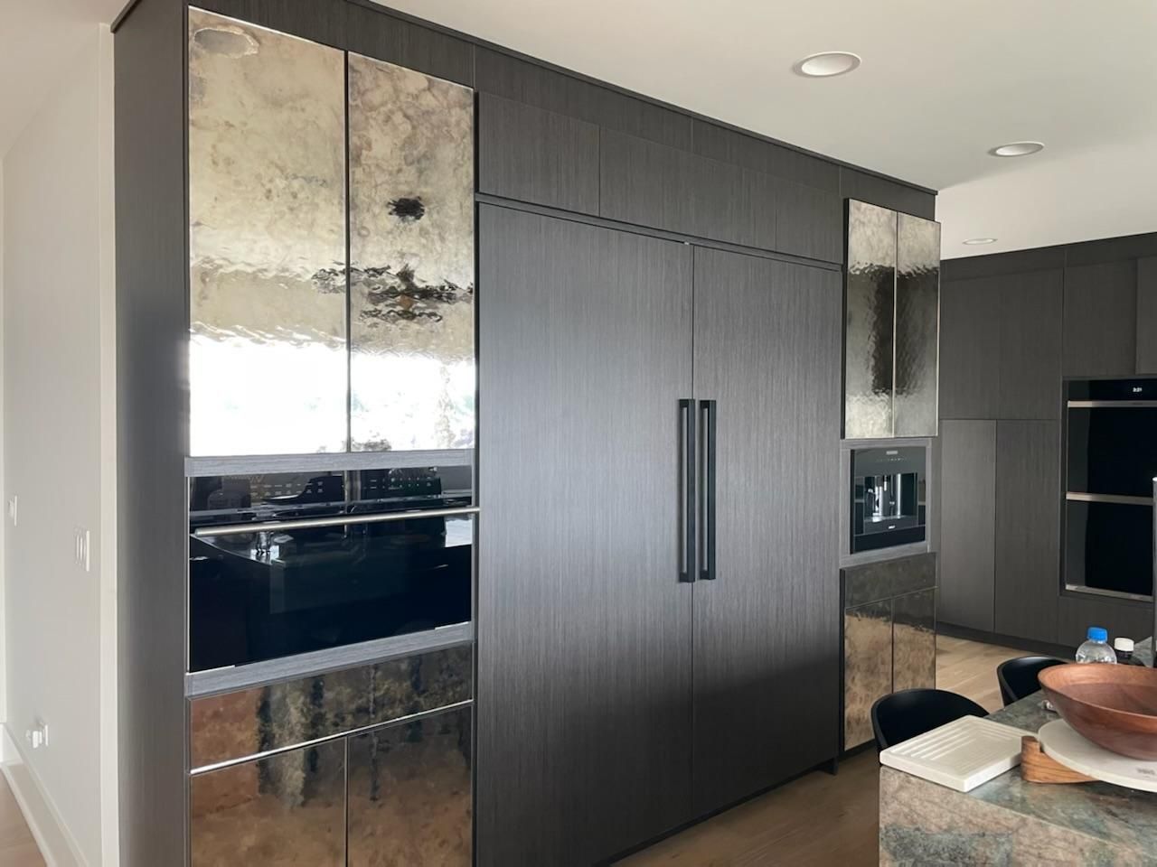 A modern style kitchen with a refrigerator, stove, microwave, and sink