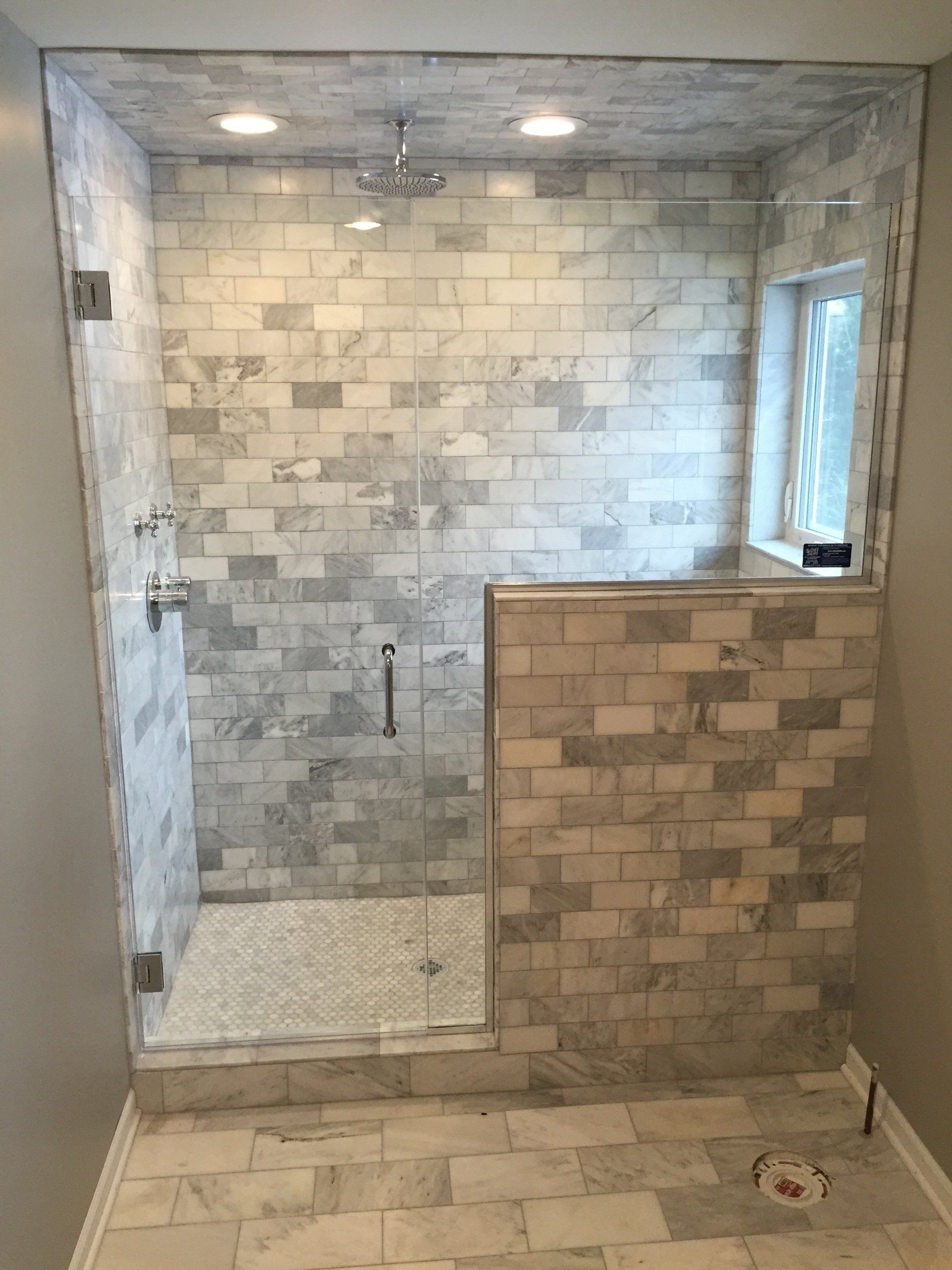 A bathroom with a walk in shower with a glass door