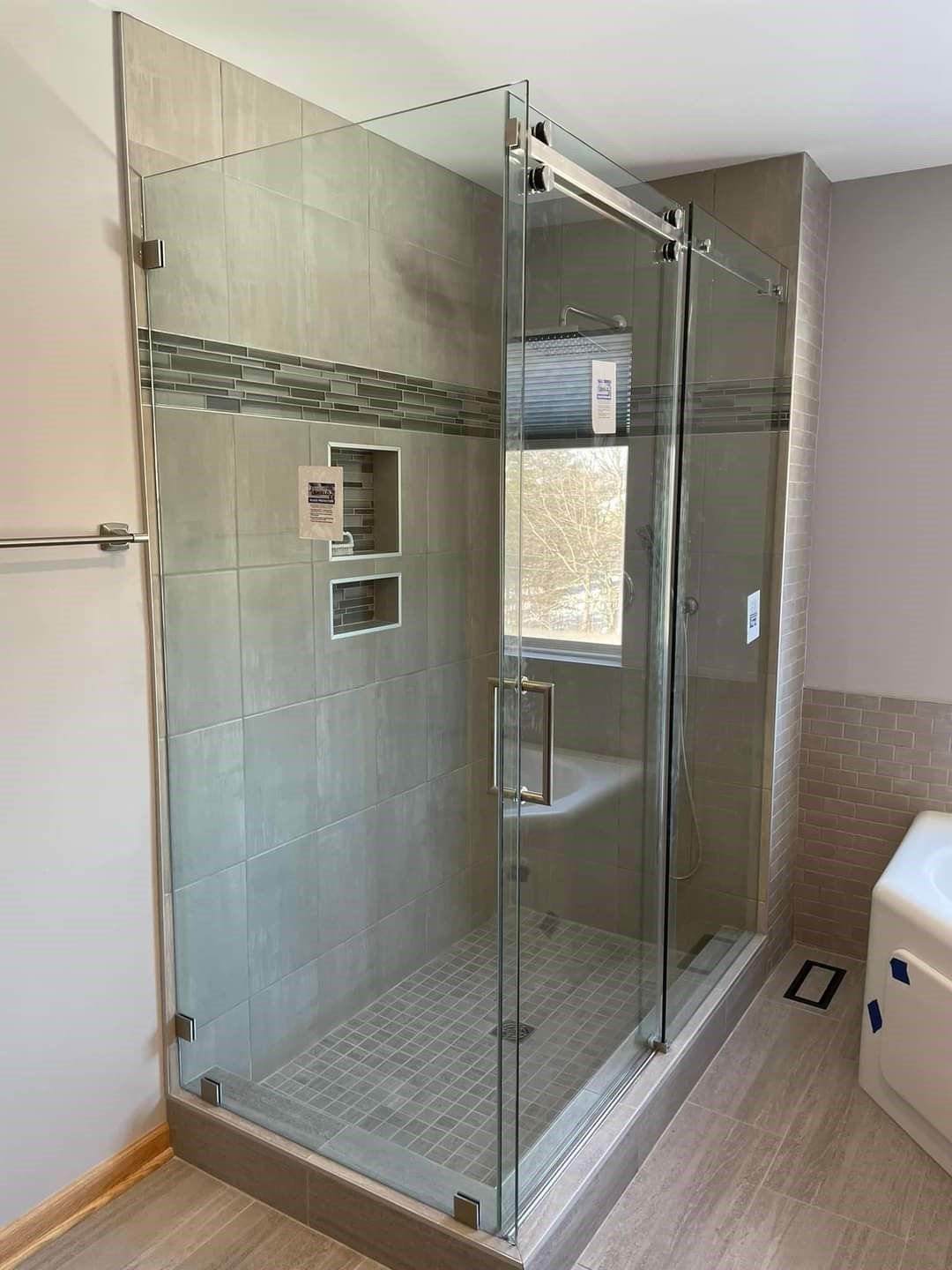 A bathroom with a sliding glass shower door and a tub